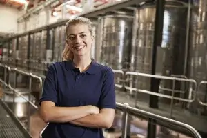 Portrait of a young white woman working at a wine factory